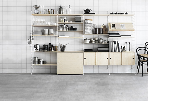 String shelving system. Shown here with a combination of white floor panels and birch shelves, cabinets and fold out table.