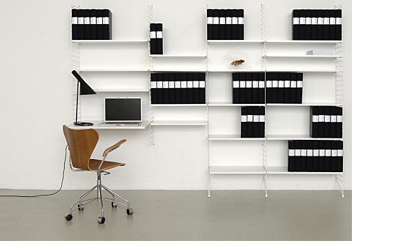 String shelving system. Shown here with a combination of white floor and wall panels with white shelves and work surface.